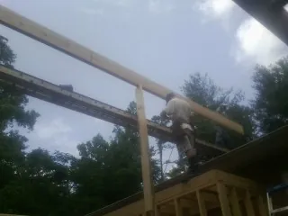 Carpenter setting a ridge beam over a new addition frame — Ice Dam Removal by Roofing Brothers in Castle Rock