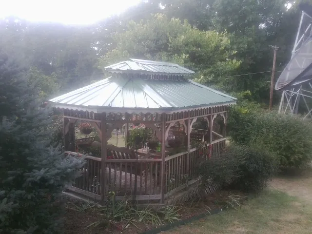 Green metal roof on a backyard gazebo surrounded by garden beds in Castle Rock