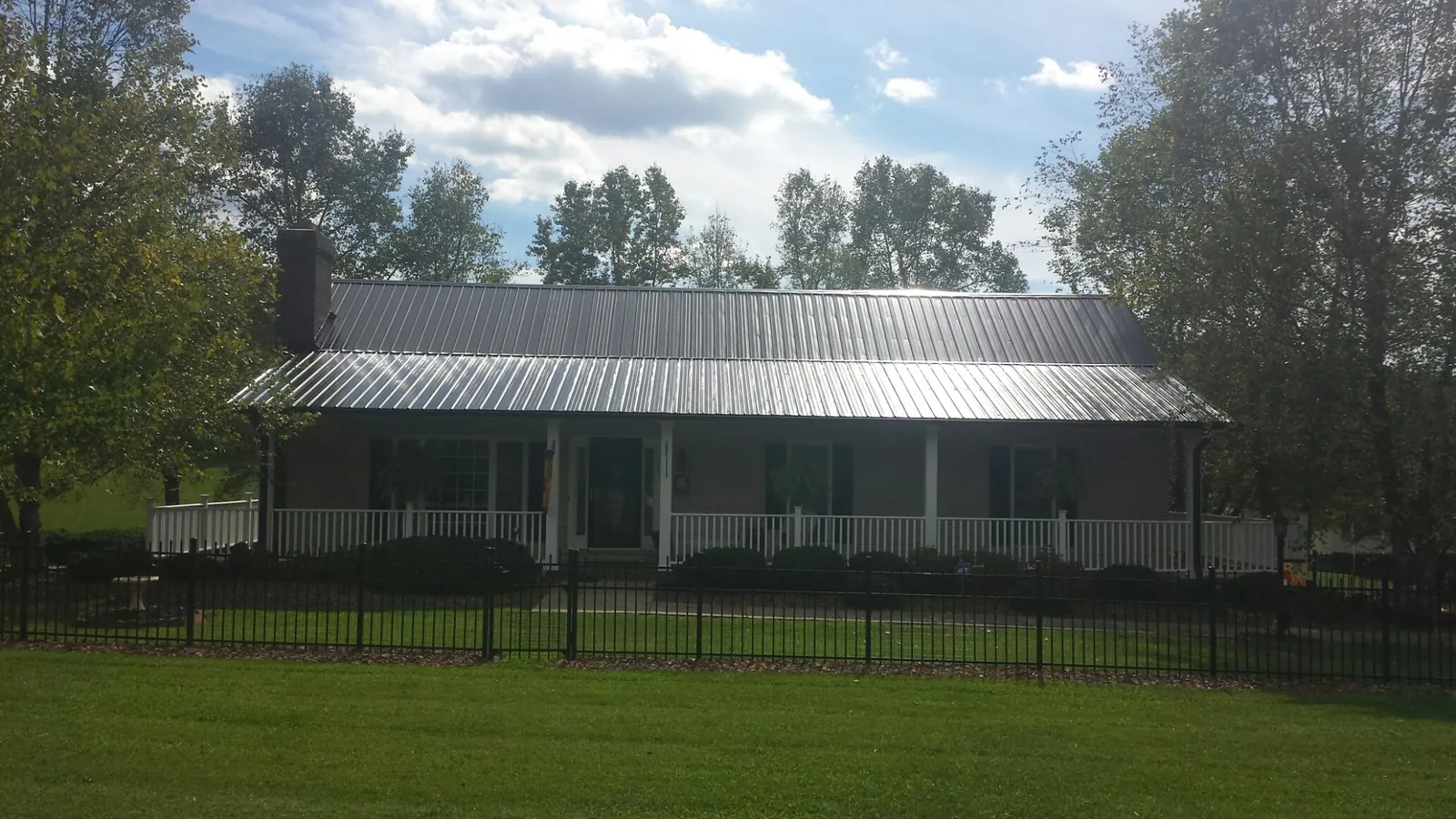 Gray metal roof on a brick ranch with a full width front porch — Gutter Guard Installation work by our crew in Castle Rock