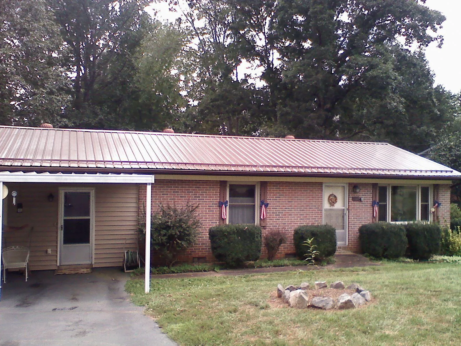 Bronze metal roof and carport on a brick ranch home — Roof Repair work by our crew in Castle Rock